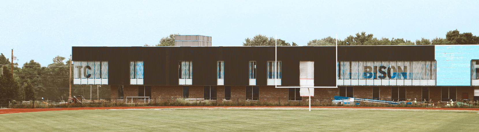 An image of a building behind a football field that says TC Bison.
