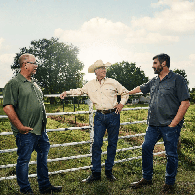 Farmers discussing agricultural financing and operational goals.