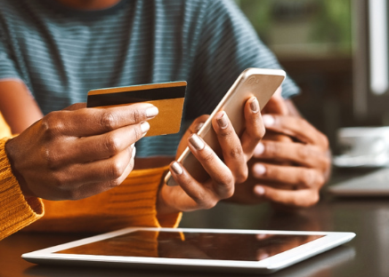 Photo of woman holding phone and credit card