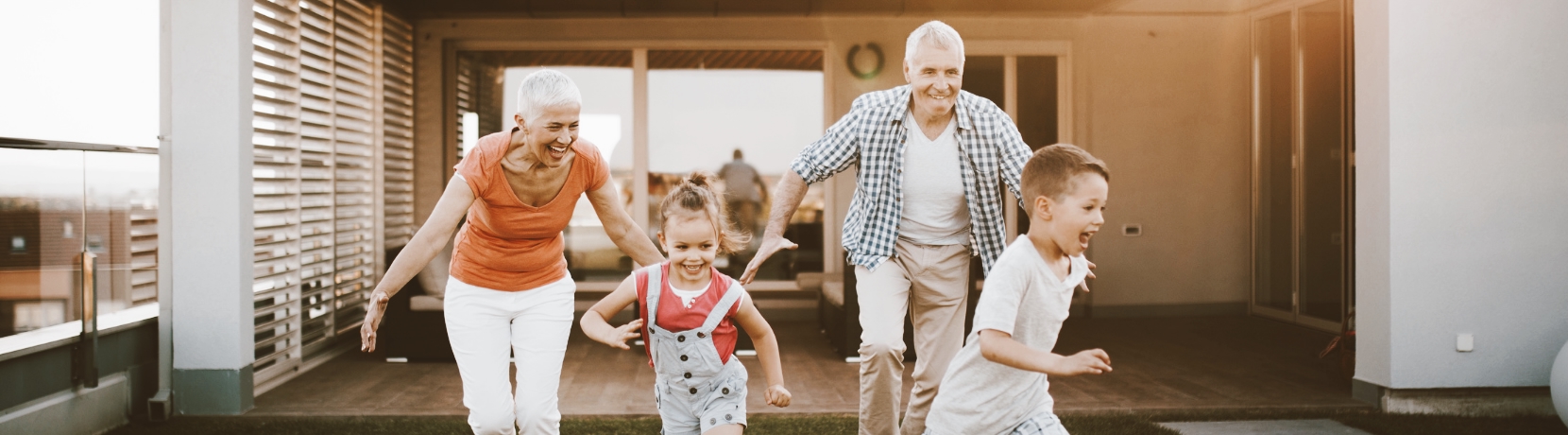 Grandparents playing with their grandkids in the backyard