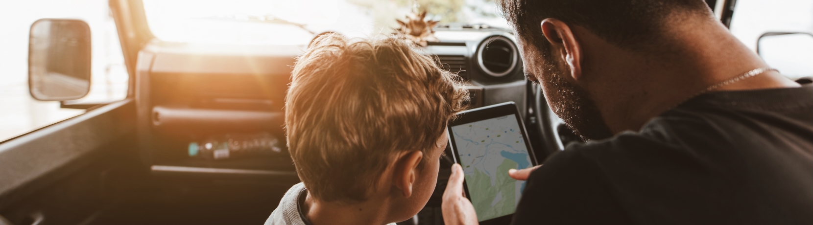 Dad and son looking at map on phone in the car