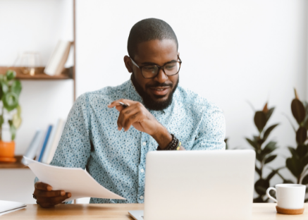 Business man working on his computer and looking over paper work